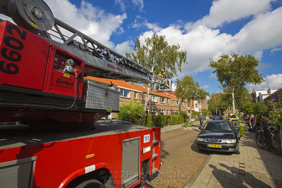 Brandweer zaagt scheef staande boom in stukken