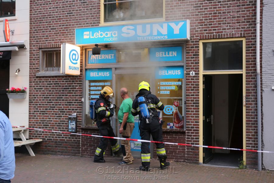 Hoge vlammen bij brand achter telefoonwinkel aan de Lange Herenstraat