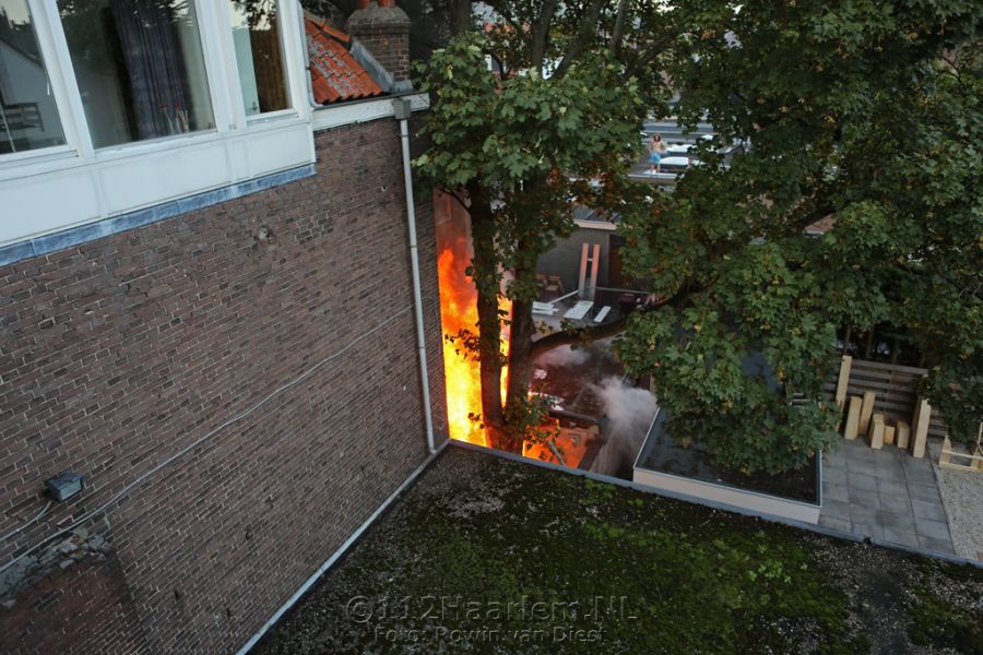 Hoge vlammen bij brand achter telefoonwinkel aan de Lange Herenstraat