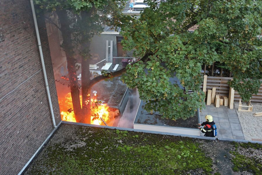 Hoge vlammen bij brand achter telefoonwinkel aan de Lange Herenstraat