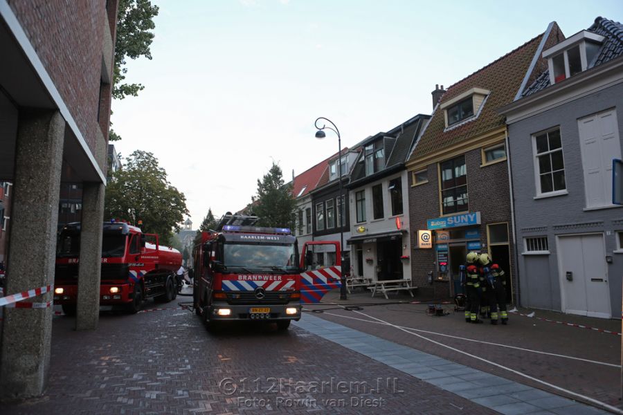 Hoge vlammen bij brand achter telefoonwinkel aan de Lange Herenstraat